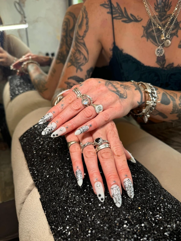 Glitter nail art with crystal embellishments and silver rings